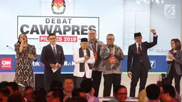 Cawapres nomor urut 01 dan nomor urut 02, Ma'ruf Amin dan Sandiaga Uno didampingi moderator serta Ketua KPU Arief Budiman berfoto bersama seusai mengikuti debat cawapres 2019 di Hotel Sultan, Jakarta, Minggu (17/3). (Liputan6.com/Johan Tallo)