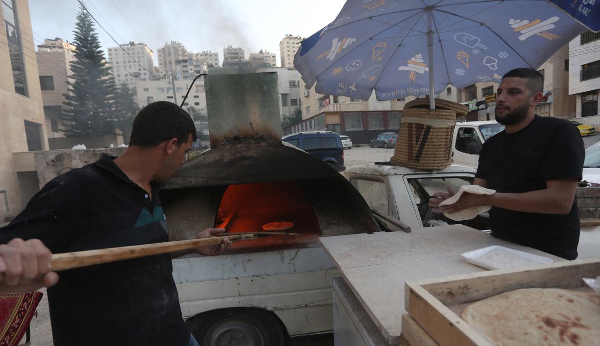 Penjual roti Palestina Mohammed Abu Saud menyiapkan roti di Kota Nablus, Tepi Barat, (3/5/2020). Abu Saud menjual roti keliling untuk membantu warga mendapatkan roti ketika mereka berada di rumah. (Xinhua/Ayman Nobani)