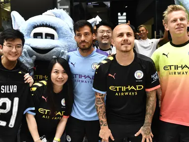 Pemain Manchester City David Silva, Angelino dan Oleksandr Zinchenko foto bersama dengan penggemar selama acara promosi di Hong Kong (23/7/2019). The Citizens akan menghadapi Kitchee SC dalam laga uji cobadi Hong Kong Stadium pada 24 Juli 2019. (AFP Photo/Anthony Wallace)