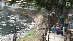 Warga berjualan di samping Kali Krukut yang dipenuhi sampah di kawasan Karet, Jakarta, Rabu (19/9). Kurangnya perhatian pihak terkait menyebabkan Kali Krukut dipenuhi sampah. (Liputan6.com/Immanuel Antonius)