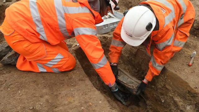 Pekerja mengangkat plakat kuburan Kapten Matthew Flinders. (Supplied: HS2 Limited)