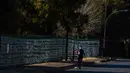Pejalan kaki melewati pita-pita yang telah diikatkan ke pagar gereja St James Presbyterian di Bedford Gardens, Johannesburg, Rabu (29/7/2020). Pita tersebut mewakili warga Afrika Selatan yang meninggal akibat virus corona COVID-19. (AP Photo/Themba Hadebe)