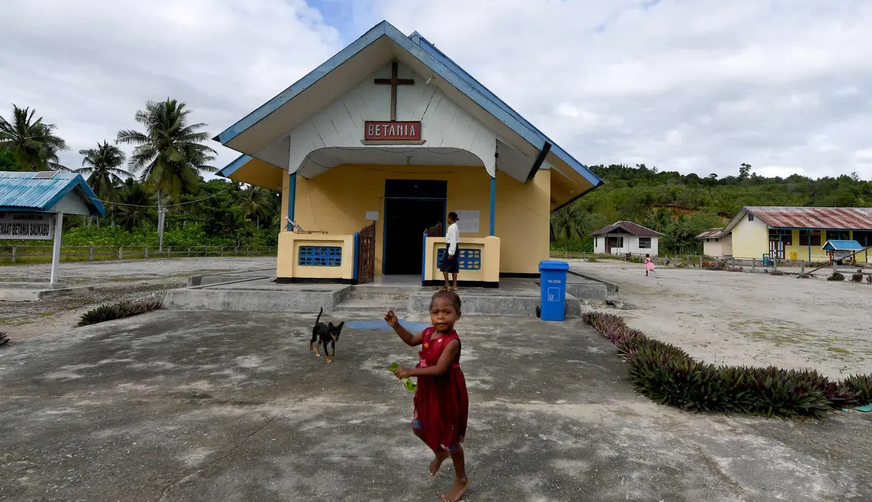 Seorang anak suku Byak Betew bermain di luar gereja pada hari Minggu di pulau Saukabu, satu dari 1.500 pulau di Raja Ampat 20 Agustus 2017. Raja ampat merupakan salah satu habitat laut paling banyak keanekaragaman hayati di bumi. (AFP Photo/Goh Chai Hin)