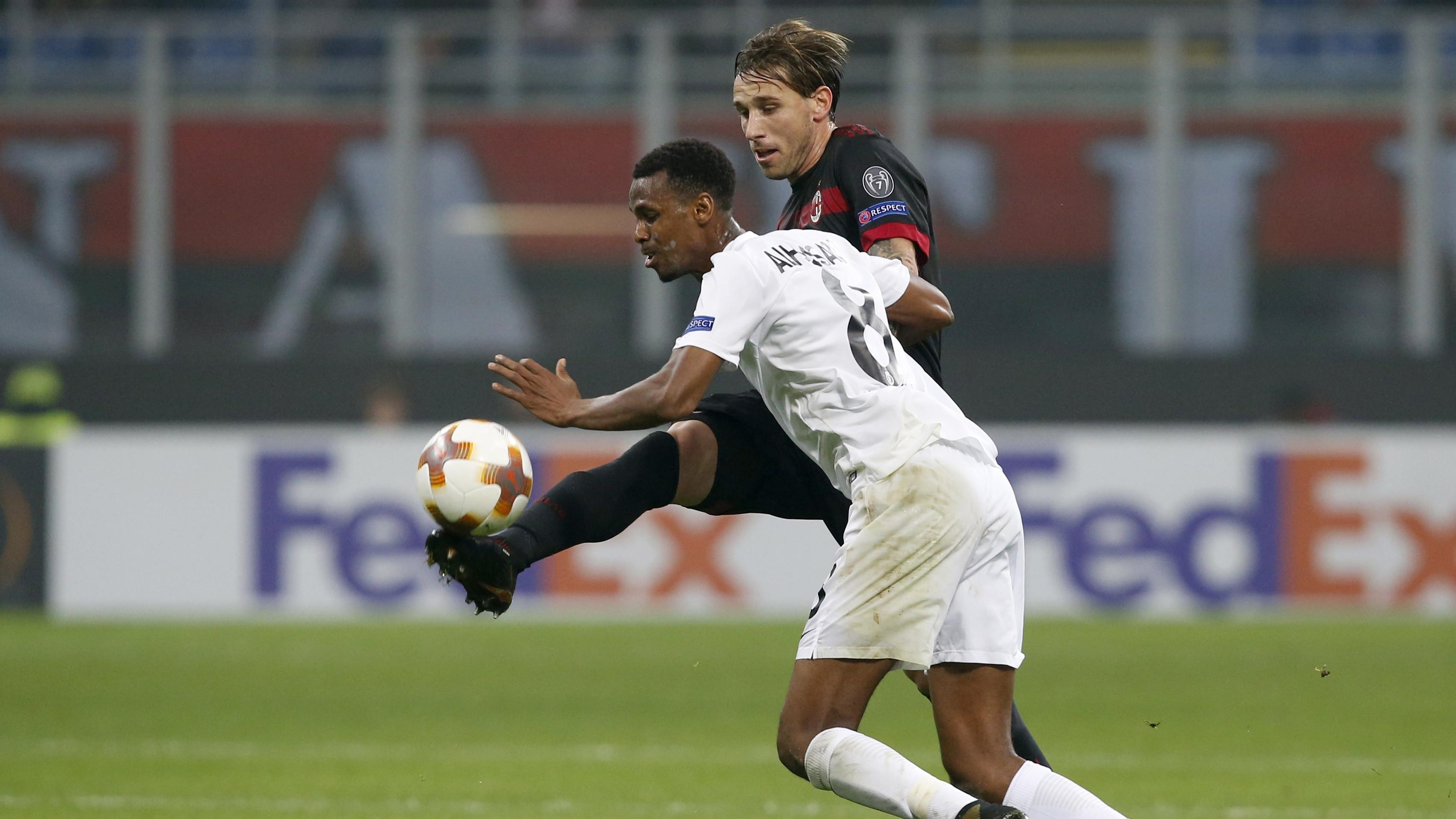 Aksi pemain AC Milan, Lucas Biglia (kanan) menghalau bola dari pemain Austria Wien, Abdullahi Ibrahim Alhassan pada laga grup D Liga Europa di San Siro, Milan, (23/11/2017). Milan menang telak 5-1. (AP/Antonio Calanni)