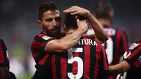 Pemain AC Milan, Giacomo Bonaventura bersama rekan setimnya, Fabio Borini merayakan gol ke gawang Bologna dalam lanjutan pekan ke-16 Liga Italia di Stadion San Siro, Senin (11/12). AC Milan menang tipis 2-1 atas Bologna. (AFP PHOTO / MARCO BERTORELLO)