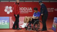 Pebulu tangkis Indonesia, Christian Adinata (tengah) meninggalkan lapangan dengan kursi roda saat semifinal tunggal putra Malaysia Masters 2023 melawan pebulu tangkis India, Prannoy HS di Bukit Jalil Axiata Arena, Kuala Lumpur, Malaysia, Sabtu (27/05/2023). Adinata gagal melanjutkan pertandingan karena cedera lutut saat ia tertinggal 17-19. (AP Photo/Kien Huo)