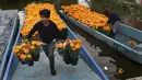 Buruh tani memindahkan bunga cempasúchil di atas perahu melalui kanal Xochimilco di Mexico City, Rabu (19/10/2022). Orang Meksiko meyakini bahwa Cempasuchil atau bunga marigold memudahkan jiwa-jiwa orang mati untuk mengunjungi mereka yang masih hidup selama dua hari itu. (AP Photo/Marco Ugarte)