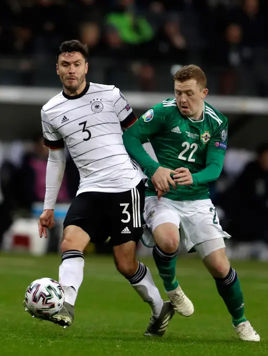 Gelandang Timnas Jerman, Jonas Hector berebut bola dengan pemain Timnas Irlandia Utara, Shayne Lavery pada laga Grup C Kualifikasi Piala Eropa 2020 di Commerzbank Arena, Selasa (19/11/2019). Timnas Jerman sanggup membenamkan Irlandia Utara dengan skor telak 6-1. (AP/Michael Probst)