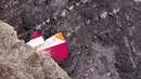 Bagian pesawat Germanwings berwarna merah, putih, kuning terlihat menyelip di bebatuan pegunungan Alpen, Prancis, Selasa (24/3/2015). Pesawat itu jatuh dalam perjalanan dari Barcelona menuju Dusseldorf, Jerman. (AFP PHOTO /DENIS BOIS /GRIPMEDIA /AFP TV)