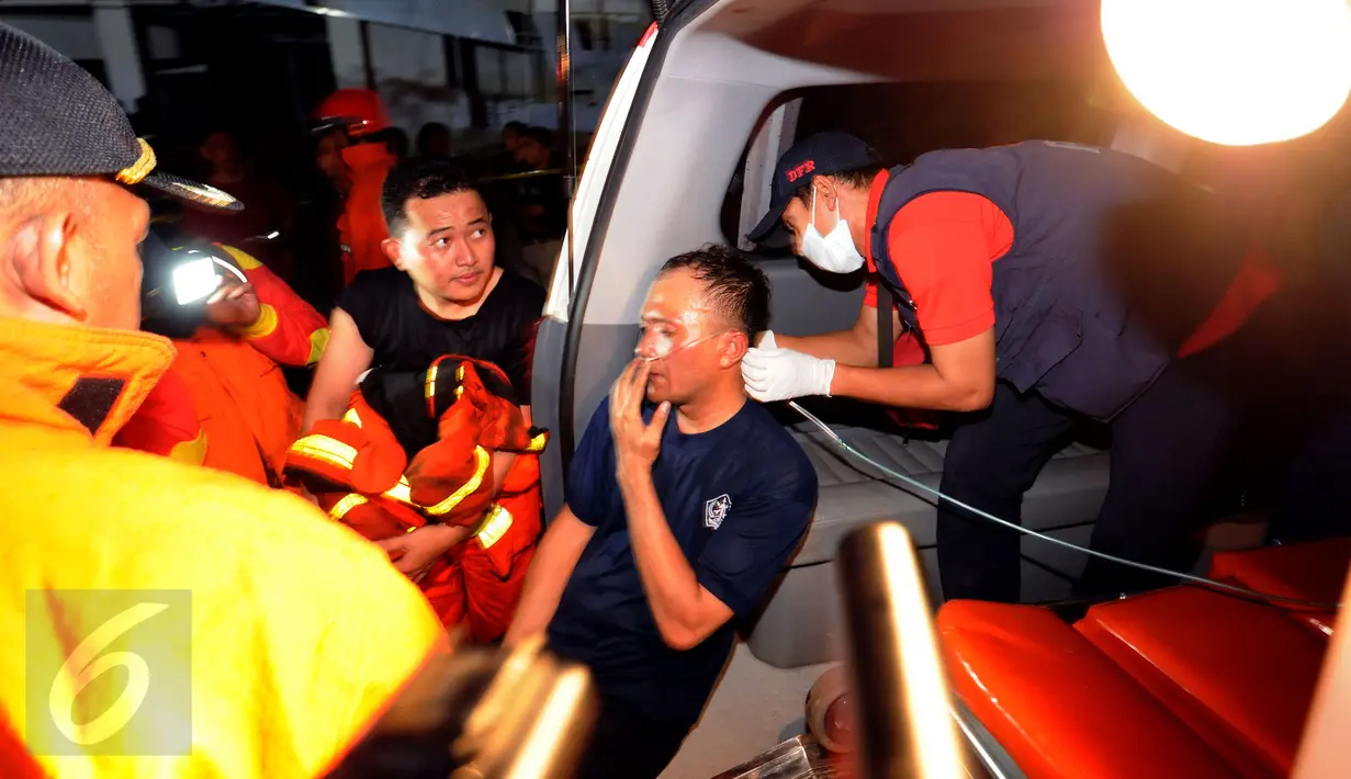 Seorang petugas pemadam mendapat perawatan usai mengevakuasi pekerja yang terjebak kebakaran di bangunan Gedung Swiss Belhotel, Kelapa Gading, Jakarta, Minggu (7/8). Dua pekerja tewas saat terjadi kebakaran. (Liputan6.com/Helmi Fithriansyah)