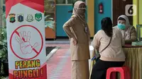 Orangtua murid berkonsultasi terkait pendaftaran daring PPDB tahun ajaran 2021/2022 di Posko Pelayanan PPDB Jakarta Selatan, SMA Negeri 70 Bulungan, Jakarta, Senin (21/6/2021). Pendaftaran PPDB jalur zonasi untuk SMP dan SMA di DKI akan dibuka pada 28 Juni 2021. (Liputan6.com/Herman Zakharia)