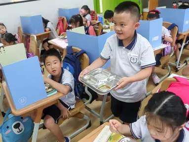 Seorang siswa berjalan mengembalikan piring kosongnya di sekolah dasar di Distrik Changning, Shanghai, China timur, pada 2 September 2020. Sekolah dasar tersebut mempromosikan kampanye "Bersihkan Piringmu" untuk mengurangi limbah makanan saat semester baru dimulai. (Xinhua/Ding Ting)