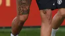 Marcos Rojo menunjukan tato Singa miliknya saat mengikuti sesi latihan di club training complex, Carrington, Manchester, (11/9/2017). MU akan melawan FC Basel di grup A Liga Champions. (AFP/Paul Ellis)