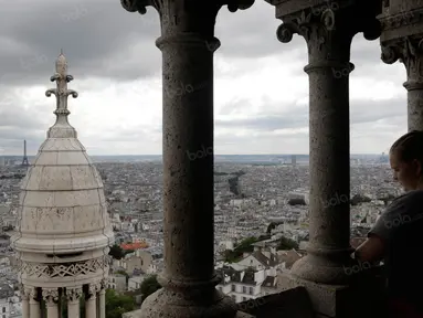 Pengunjung memandangi suasana keindahan Kota Paris dari atas Bassilique du Sacre-Coeur yang terletak di Montmartre, Prancis, Jumat (8/6/2016). (Bola.com/Vitalis Yogi Trisna)