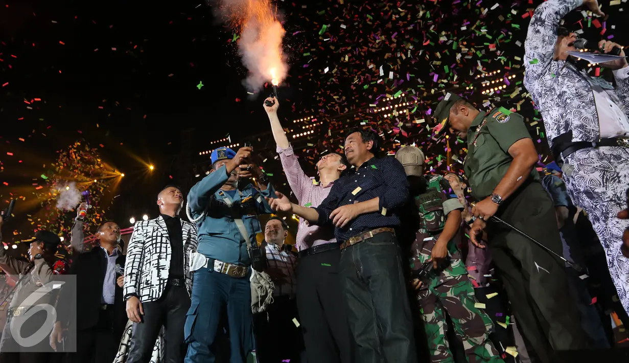 Gubernur DKI Jakarta, Basuki T Purnama didampingi Wagub DKI Djarot Syaiful Hidayat menembakan ke atas pertanda tahun baru 2016 di panggung Move On Party 2016 di Pantai Carnaval Ancol, Jakarta, Jumat (1/1/2016). (Liputan6.com/Herman Zakharia)
