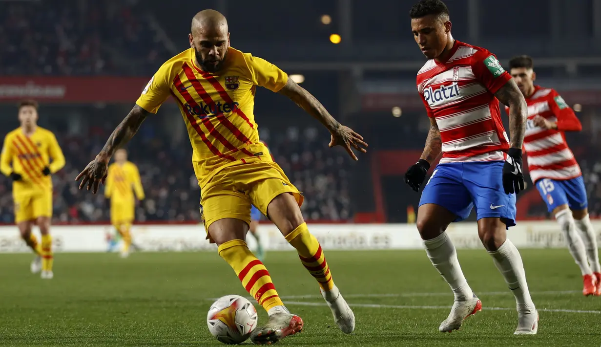 Gelandang Barcelona Dani Alves saat berebut bola dengan pemain Granada dalam jornada ke-20 Liga Spanyol 2021/2022 di Stadion Los Carmenes, Minggu (9/1/2022) dini hari WIB. Barcelona ditahan imbang 1-1 Granada. (AP Photo/Fermin Rodriguez)