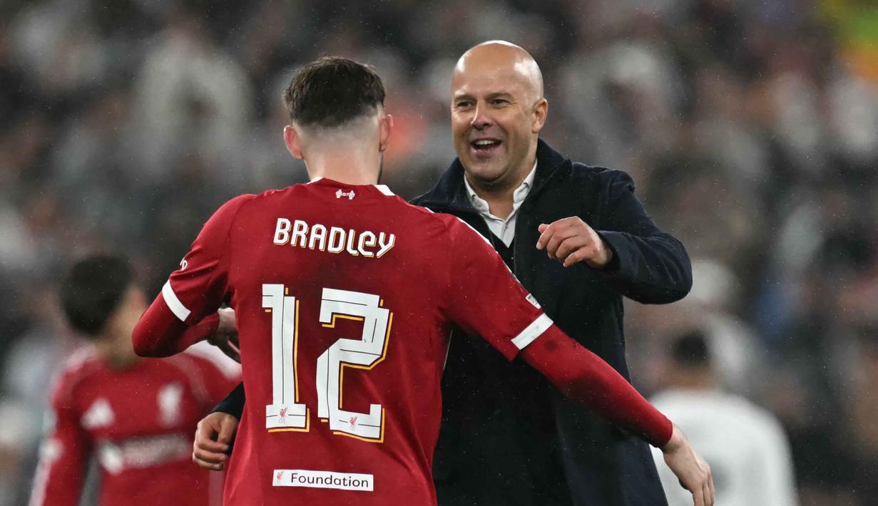 Manajer Liverpool asal Belanda, Arne Slot (kanan), memberi selamat kepada bek Liverpool asal Irlandia Utara, Conor Bradley usai pertandingan pekan keempat Liga Champions 2025-2026 melawan Real Madrid di Stadion Anfield, Inggris, pada Selasa 4 November 2025 waktu setempat atau Rabu (5/11/2025) dini hari WIB. Kemenangan ini membawa Liverpool naik ke peringkat enam klasemen sementara fase liga Liga Champions 2025-2026 dengan koleksi poin 9, sama dengan milik Real Madrid yang kini duduk di peringkat kelima. (Paul ELLIS/AFP)