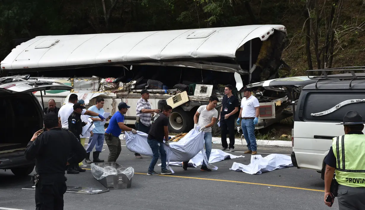 Tim forensik membawa korban  yang tewas dalam kecelakaan bus yang menabrak truk trailer di Gualan, Guatemala (21/12/2019). Kecelakaan tersebut menewaskan sedikitnya 21 orang dan menyebabkan belasan orang luka-luka. (AP Photo/Carlos Cruz)