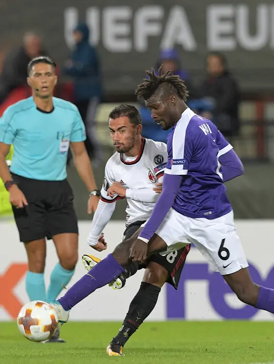 Gelandang AC Milan, Suso berusaha mengumpan bola dari kawalan bek Austria Wien, Abdul Kadiri Mohammed saat bertanding pada Grup D Liga Europa di Ernst Happel Stadium, (14/9). Suso mencetak satu gol dipertandingan ini. (AFP Photo/Joe Klamar)