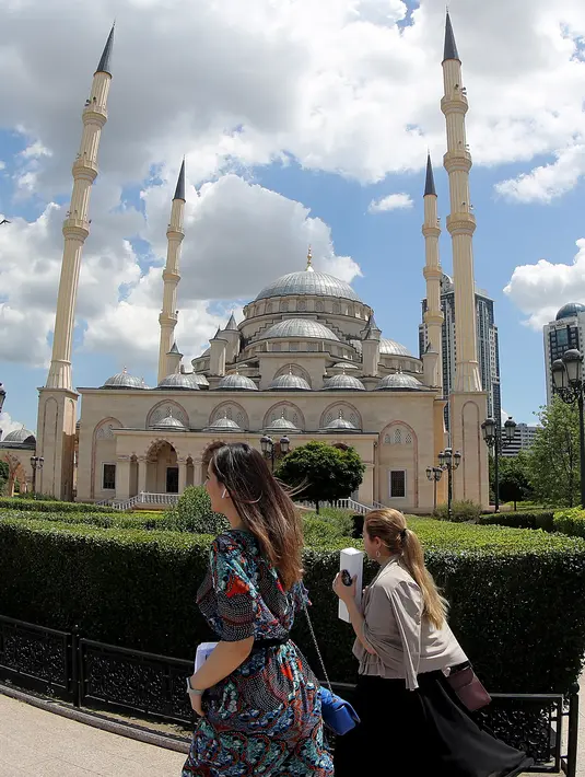 Pejalan kaki melintasi Masjid Akhmad Kadyrov di alun-alun Kota Grozny, pusat ibu kota Chechnya, 9 Juni 2018. Masjid tersebut memiliki luas 5.000 meter persegi dan berdiri di atas lahan seluas 14 hektare. (AFP PHOTO/KARIM JAAFAR)