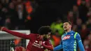 Gelandang Liverpool, Mohamed Salah berebut bola dengan pemain, Napoli Mario Rui pada matchday keenam Grup C Liga Champions di Stadion Anfield, Selasa (11/12). Gol Salah mengantarkan Liverpool mengalahkan Napoli dengan skor 1-0. (Paul ELLIS / AFP)