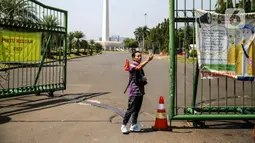 Warga berswafoto di depan kawasan Monumen Nasional (Monas), Jakarta, Minggu (26/7/2020). Sejumlah warga mulai mengunjungi kawasan Monas meski masih ditutup sementara di masa PSBB transisi. (Liputan6.com/Faizal Fanani)