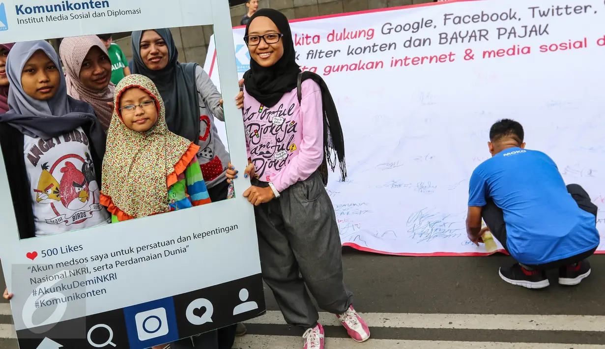 Warga pose saat aksi penandatanganan spanduk dukungan di Car Free Day Jalan MH Thamrin, Jakarta, Minggu (25/9). Aksi tersebut mengajak Facebook, Google, YouTube dan Twitter untuk bayar pajak. (Liputan6.com/Fery Pradolo)