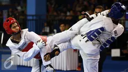 Taekwondoin Jawa Barat, Dinggo (kiri) melakukan tendangan ke arah pemain DIY, Okky Indera P saat laga final kelas -68kg PON XIX di Gymnasium UPI, Bandung, Senin (26/9/2016). Dinggo meraih emas setelah unggul 16-4. (Liputan6.com/Helmi Fithriansyah)