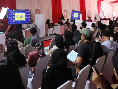 Warga menunggu panggilan nomor antrean pelayanan pembuatan paspor di Kawasan Gelora Bung Karno, Jakarta, Minggu (4/8/2024). (Liputan6.com/Angga Yuniar)