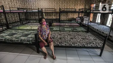 Tri duduk di antara ranjang kasur yang lama tak dihuni di yayasan penyalur asisten rumah tangga Mekar Jaya, Jakarta, Selasa (11/5/2021). Pandemi Covid-19 yang berkepanjangan menyebabkan jasa penyalur Infal yang biasa ramai di kala menjelang Lebaran kini mendadak sepi. (merdeka.com/Iqbal S Nugroho)