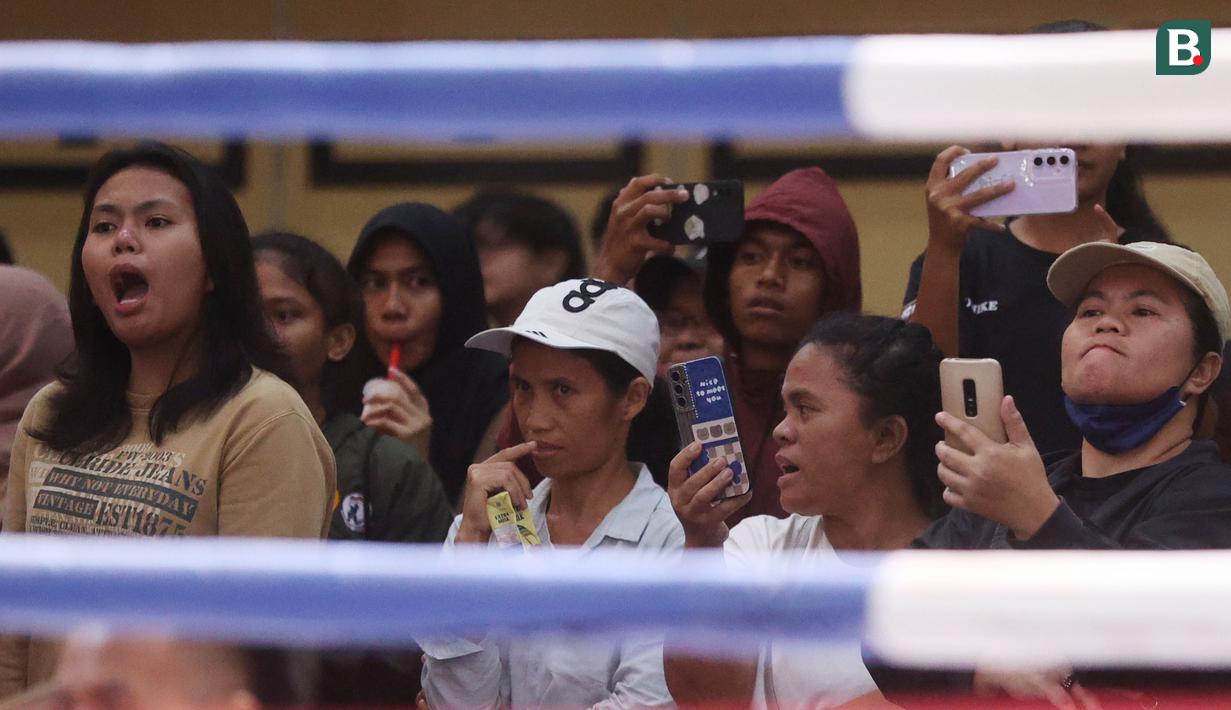 Penonton tampak serius menyaksikan pertandingan Kejuaraan Nasional MMA U-18 2024 di Golden Boutique Hotel, Kemayoran, Jakarta, Sabtu (11/5/2024). (Bola.com/M Iqbal Ichsan)