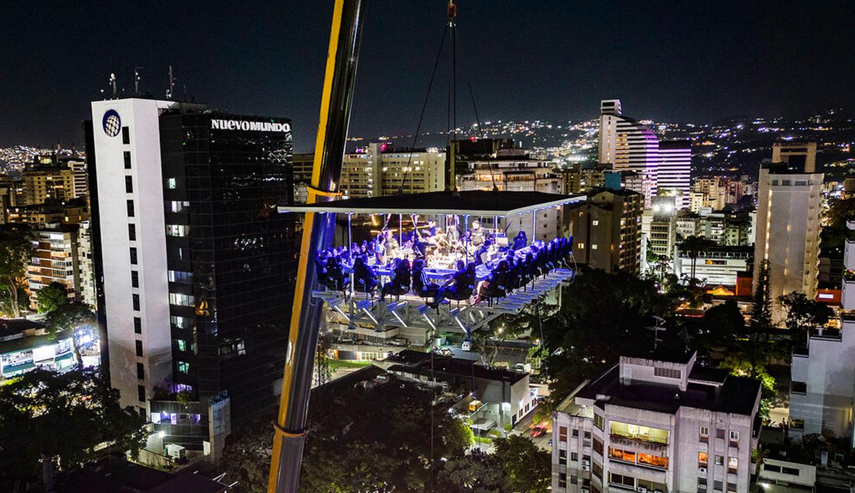 Pengunjung menikmati makan malam di Restoran Altum, Caracas, Venezuela, 22 Desember 2022. Restoran Altum menawarkan sensasi menyantap makanan di atas ketinggian 50 meter. (AP Photo/Matias Delacroix)