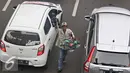 Pedagang menawarkan dagangan mainannya di tengah kemacetan kawasan Harmoni, Jakarta, Selasa (19/4). Kemacetan yang semakin parah di Ibukota menjadi keuntungan tersendiri bagi para pedagang asongan untuk mencari nafkah.(Liputan6.com/Immanuel Antonius)