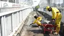 Petugas Bina Marga memerbaiki lantai Jembatan Penyeberangan Orang (JPO) yang berlubang di kawasan Tebet, Jakarta, Kamis (27/8/2020). Perbaikan dilakukan guna meningkatkan kenyamanan bagi pejalan kaki yang melintas. (Liputan6.com/Immanuel Antonius)
