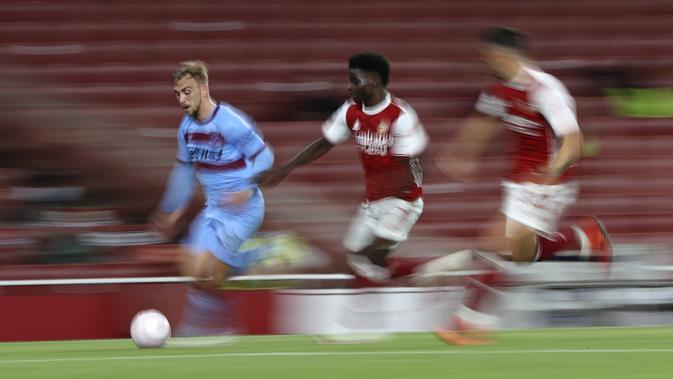 Penyerang West Ham,  Jarrod Bowen membawa bola dari kejaran gelandang Arsenal, Bukayo Saka pada pertandingan lanjutan Liga Inggris di Stadion Emirates di London, Inggris, Sabtu (19/9/2020). Arsenal menang tipis 2-1 atas West Ham. (AP Photo/Ian Walton, Pool)