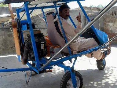 Muhammad Fayyaz duduk dalam pesawat buatannya di Desa Tabur, Provinsi Punjab, Pakistan, 8 April 2019. Penjual popcorn asal sebuah desa di Pakistan tersebut sukses membuat pesawat sendiri dari alat seadanya. (ARIF ALI/AFP)