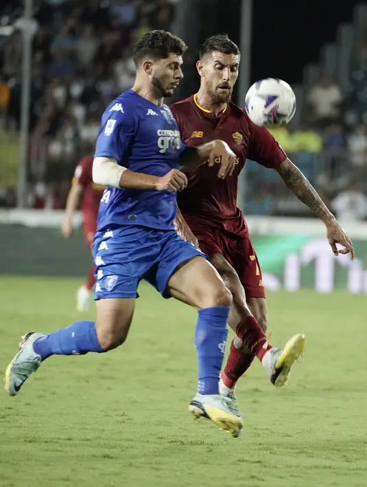 Gelandang AS Roma Lorenzo Pellegrini berebut bola dengan bek Empoli Liberato Cacace  dalam partai Serie A 2022/2023 giornata 6 di Stadio Carlo Castellani, Selasa (13/9/2022) dini hari WIB. Duel Empoli vs Roma berakhir dengan skor 2-1 untuk kemenangan Serigala Ibu Kota --julukan AS Roma.  (Marco Bucco/LaPresse via AP)