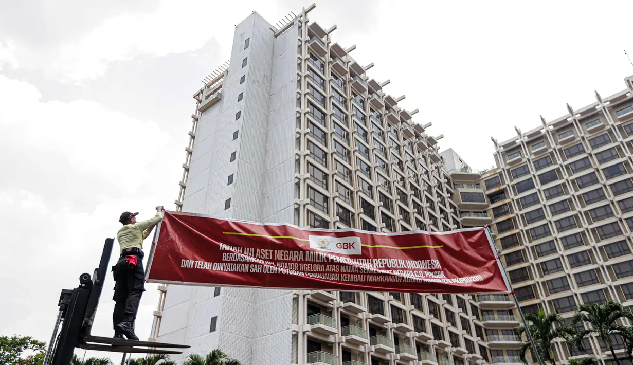 Petugas memasang spanduk pemberitahuan di depan Hotel Sultan, Kompleks GBK, Jakarta, Rabu (4/10/2023). Pusat Pengelolaan Kompleks Gelora Bung Karno (PPKGBK) memasang spanduk pemberitahuan tanah aset negara di Hotel Sultan, dan mengingatkan pengelola hotel itu segera mengosongkan lahan di Blok 15 kawasan GBK. (Liputan6.com/Faizal Fanani)