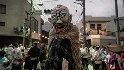 Peserta mengenakan kostum hantu saat festival Awa Odori di Kota Miyoshi, Jepang (16/8). Acara ini biasanya dimulai pada siang hari, namun pertunjukan utamanya baru dimulai pada petang hingga malam hari. (AFP Photo/Yasuyoshi Chiba)