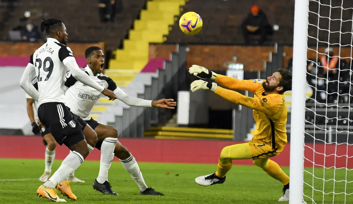 Penjaga gawang Liverpool Alisson melakukan penyelamatan saat melawan Fulham pada pertandingan Liga Premier Inggris di Stadion Craven Cottage, London, Minggu (13/12/2020). Liverpool dan Fulham bermain imbang 1-1. (Mike Hewitt/Pool via AP)