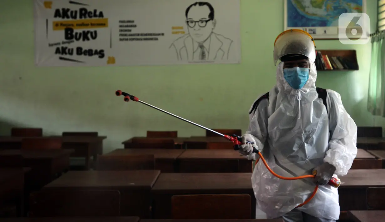 Petugas Palang Merah Indonesia (PMI) menyemprotkan cairan disinfektan di SMA 70 Jakarta, Kamis (27/1/2022). Pemprov DKI Jakarta mencatat ada 90 sekolah ditutup sementara akibat ditemukannya kasus COVID-19 varian Omicron yang tersebar di lima kota administrasi DKI Jakarta. (merdeka.com/Imam Buhori)