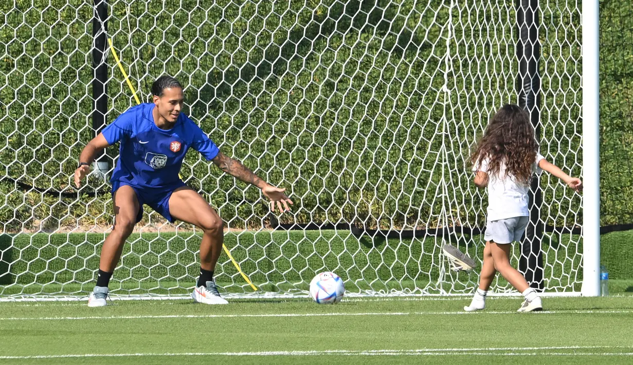 <p>Bek Timnas Belanda Virgil van Dijk bermain dengan putrinya saat pertemuan dengan kerabat usai sesi latihan di tempat latihan Universitas Qatar, Doha, Qatar, Selasa (22/11/2022). Bek Belanda ini mengakui bahwa Ekuador akan menjadi lawan yang sangat tangguh di pertandingan selanjutnya. (Alberto PIZZOLI/AFP)</p>