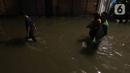 Warga sedang berjalan di tengah banjir yang melanda Jalan Bangka, Jakarta, Rabu (4/1/2023). Hujan deras yang terjadi pada Rabu sore membuat Kali Mampang meluap hingga menyebabkan banjir di kawasan tersebut dengan ketinggian bervariasi mulai dari 40 hingga 60 cm. (Liputan6.com/Herman Zakharia)