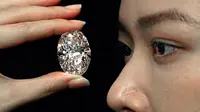 Sebuah berlian putih 102,39 karat, yang dikenal sebagai warna D, tanpa cela dipamerkan model di ruang lelang Sotheby di Hong Kong, Senin (28/9/2020).  Berlian itu diperkirakan akan terjual dengan harga 12 juta dolar AS (Rp 180 miliar) hingga 30 juta dolar AS (Rp 450 miliar). (AP Photo/Vincent Yu)