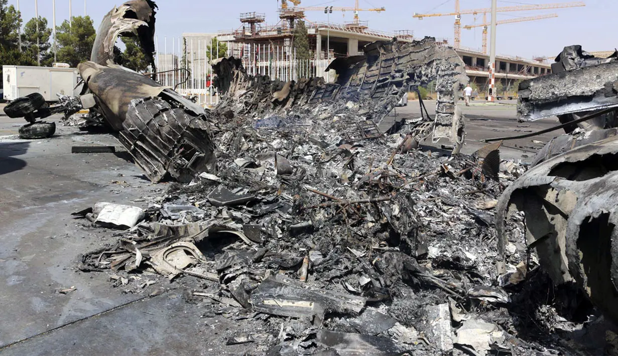 Sebuah pesawat habis terbakar pasca baku tembak antara dua kelompok bersenjata, Minggu (20/7/2014), di Bandara Internasional Tripoli, Libya, (21/7/2014). (REUTERS/Hani Amara)