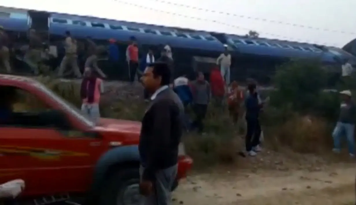 Sejumlah orang berkumpul di lokasi tergelincirnya kereta Indian Express di Negara Bagian Uttar Pradesh, India, Minggu (20/11). Sebagian besar korban berada di dua gerbong dekat mesin kereta, yang terbalik dan rusak parah. (ANI/via REUTERS)