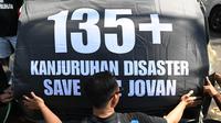 Seorang peserta aksi dalam protes di sepanjang jalan sebelum menghadiri upacara peringatan di Malang, Jawa Timur pada tanggal 1 Oktober 2023. (Juni KRISWANTO/AFP)