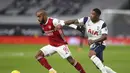 Penyerang Arsenal, Alexandre Lacazette (kiri) membawa bola dari kawalan penyerang Tottenham Hotspur, Steven Bergwijn pada pertandingan lanjutan Liga Inggris di Tottenham Hotspur Stadium di London, Inggris , Minggu (7/12/2020). Tottenham menang 2-0. (Catherine Ivill/Pool via AP)