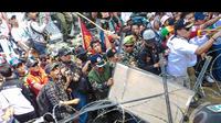 Massa Prabowo nekat menerobos kawat berduri dengan cara merusaknya dengan aneka benda, Jakarta, Kamis (21/8/2014) (Liputan6.com/Faizal Fanani)