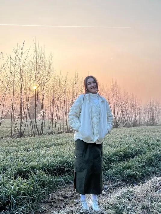 Dia terlihat mengenakan jaket tebal, rok army dan sepatu kets [instagram/ayutingting92]